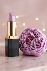 #02 Grape Ice Lipstick styled with lavender peony blossom and bokeh lights in the background