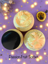 Three containers of passion fruit sorbet on a purple background with lights.