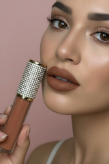 A tube of 'M01 Cinnamon Bun' lipstick with a clear, rhinestone-embellished cap