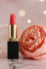 L'Paige #24 Peach Pie Aloe Stain Lipstick styled with peach peony with a rose gold background and bokeh lights