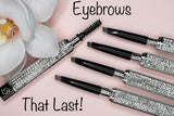 La Paz Cosmetics Luxe Crystal Eyebrow Pencil collection showing all 4 shades open with spoolie ends and crystal-encrusted cases on a pink background with a white orchid — Eyebrows That Last