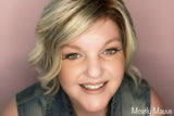 Woman with blonde hair and denim vest smiling, with 'Mostly Mauve' lipstick