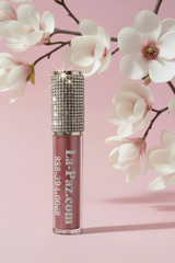 Goddess liquid metallic matte lipstick with rhinestones on a pink background with white flowers