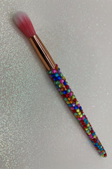Makeup brush with colorful bead handle on a glittery background