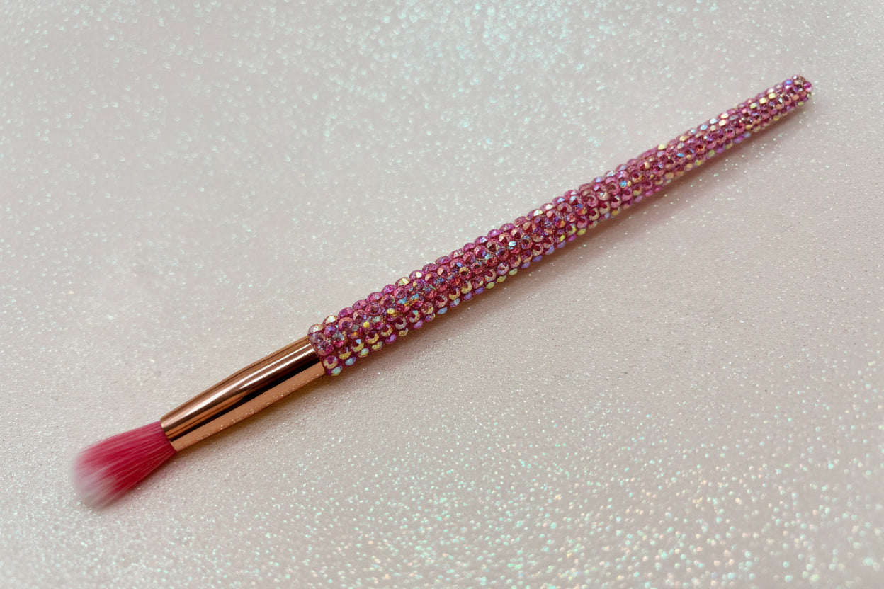 Round blending for eye makeup brush with pink bristles and a pink rhinestone handle on a sparkly background by La Paz Cosmetics