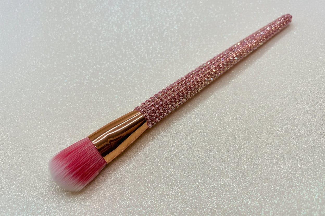Foundation Makeup brush with pink bristles and a pink rhinestone handle on a sparkly background by La Paz Cosmetics