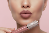 Close-up of a person holding a lip gloss with a decorative cap.