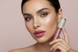 Woman holding a pink Flirt lipstick with a beige background