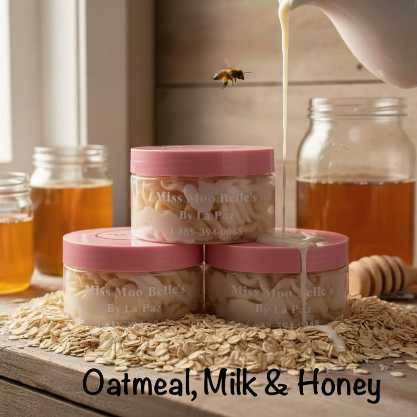 Jars labeled 'Miss Moo Belle's' with oats, milk, and honey on a wooden surface.