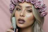 Woman holding a lip gloss with a pink background