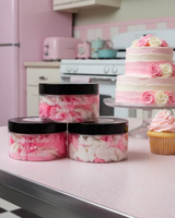 Three jars of 'Miss Moo Belle's' body butter in pink frosting sitting on a countertop.