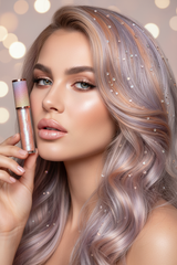 Model with silver-lavender hair and crystal hair gems holding La Paz Cosmetics Moonbeam Glaze Lux Lip Gloss with a soft iridescent lavender shimmer finish and glowing skin