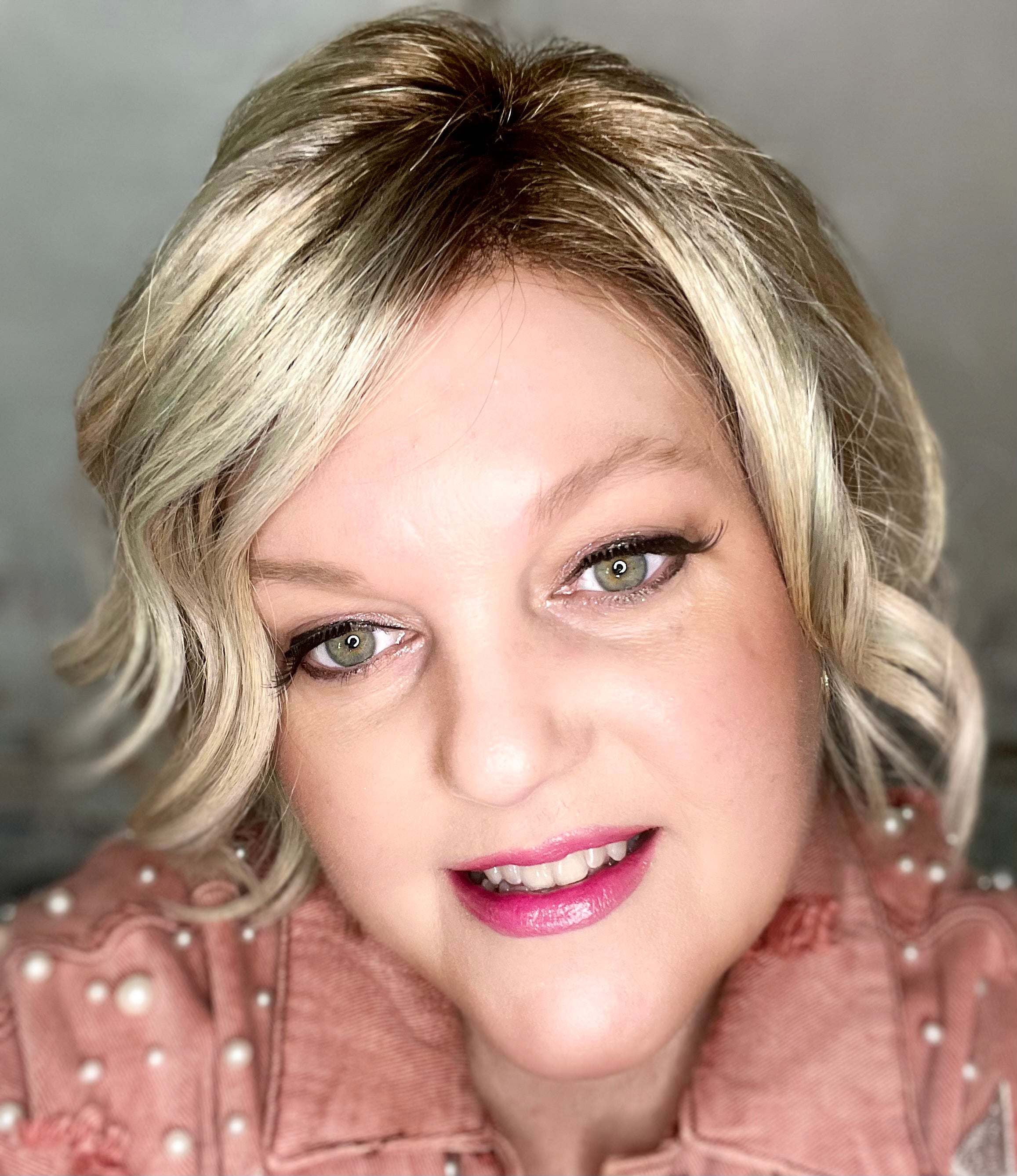 La Paz Cosmetics founder wearing #102 pink coconut color changing lipstick and a pink denim jacket