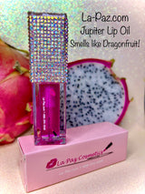 A pink Jupiter lip oil in a clear tube with a crystal embellished cap, displayed on a box with 'La-Paz.com' branding.