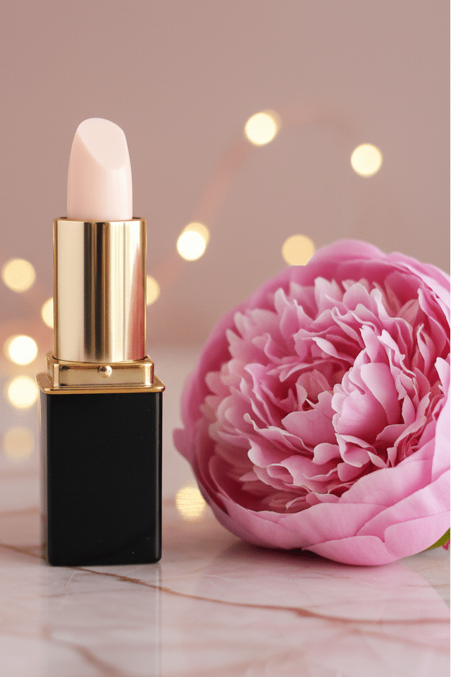 A tube of L'Paige brand lipstick in White Pink Coconut color changing shade with a pink peony.  Presented by La Paz Cosmetics