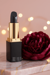 L'Paige color changing lipstick in  #106 Batgirl presented by La Paz Cosmetics and styled with a wine colored peony
