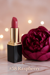 A lipstick tube by L'Paige in the color #58 Raspberry  beside a large deep pink flower