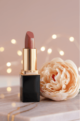 L'Paige lipstick in color #91 Fawn styled by a peach peony with bokeh fairy lights in the background