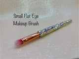 Small flat eye makeup brush with a full aurora crystal handle, gold ferrule and pink bristles by La Paz Cosmetics on a white background 