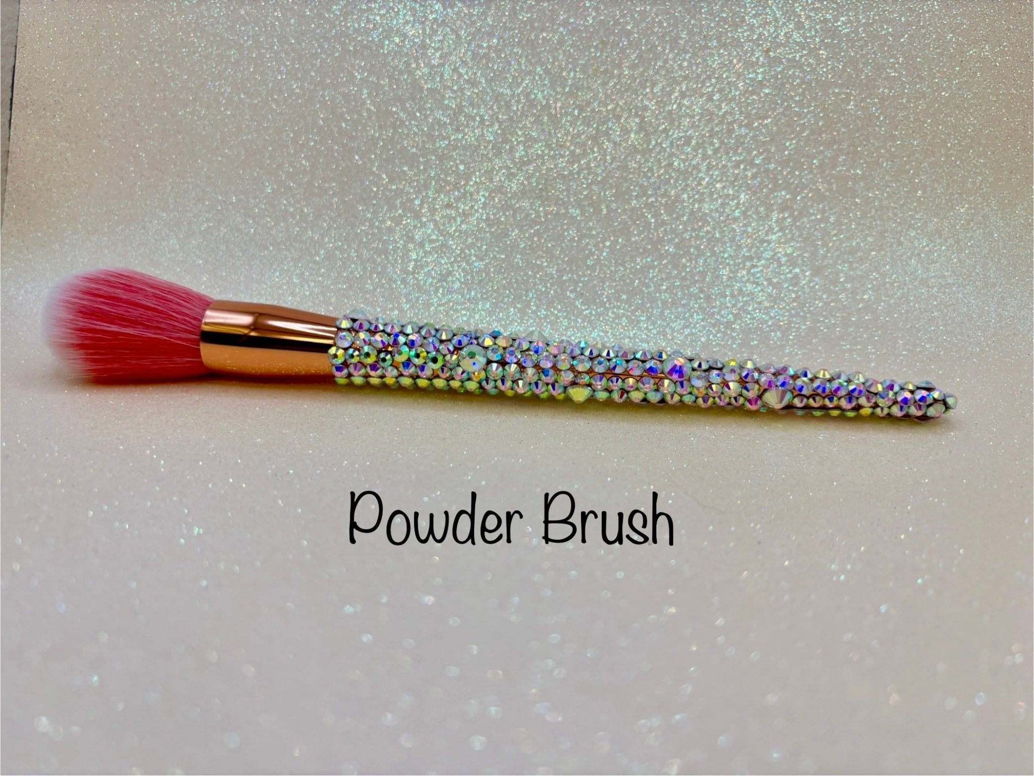 Powder Brush  with a full aurora crystal handle, gold ferrule and pink bristles by La Paz Cosmetics on a white background 