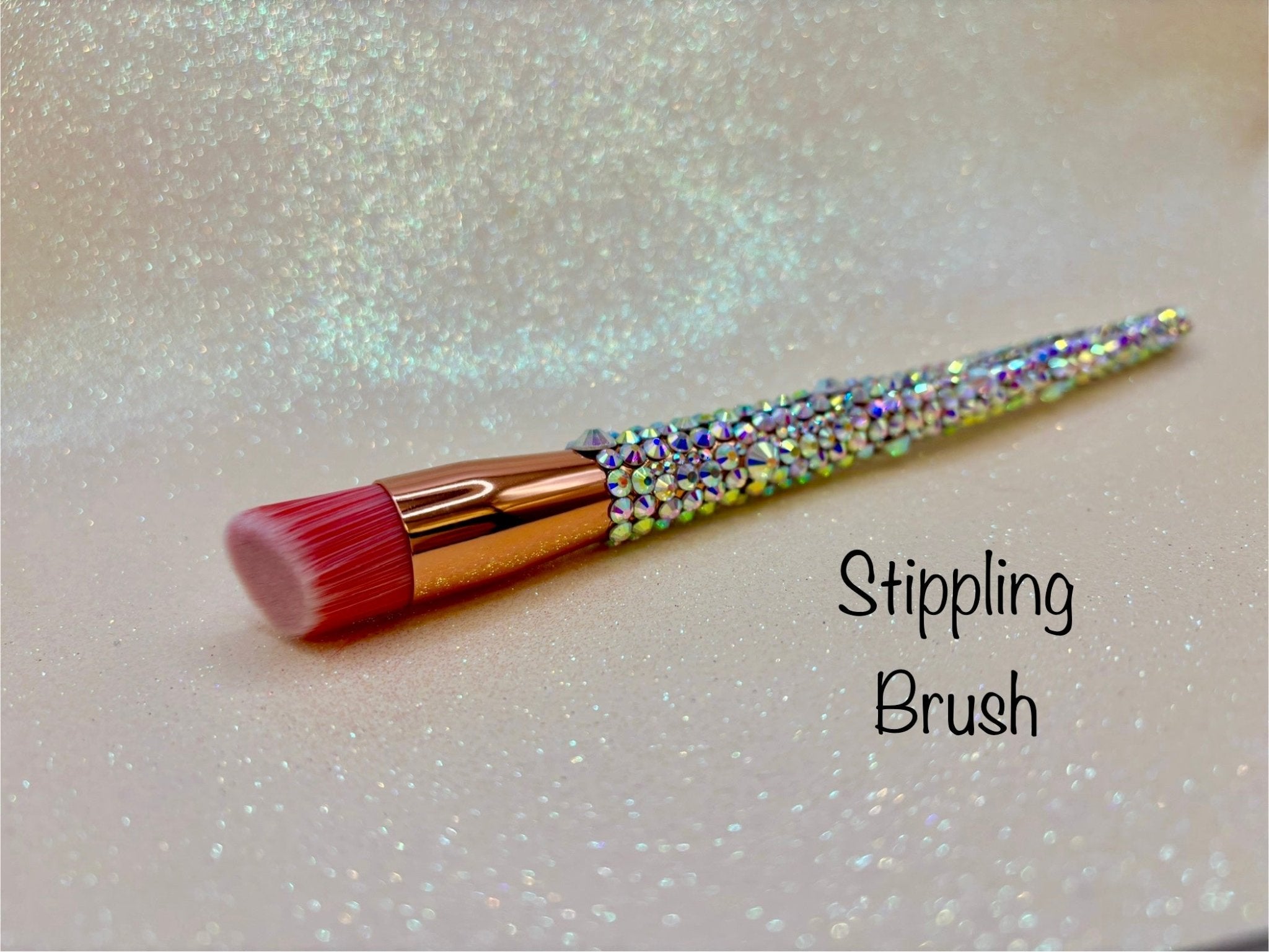 Stippling brush with a full aurora crystal handle, gold ferrule and pink bristles by La Paz Cosmetics on a white background 