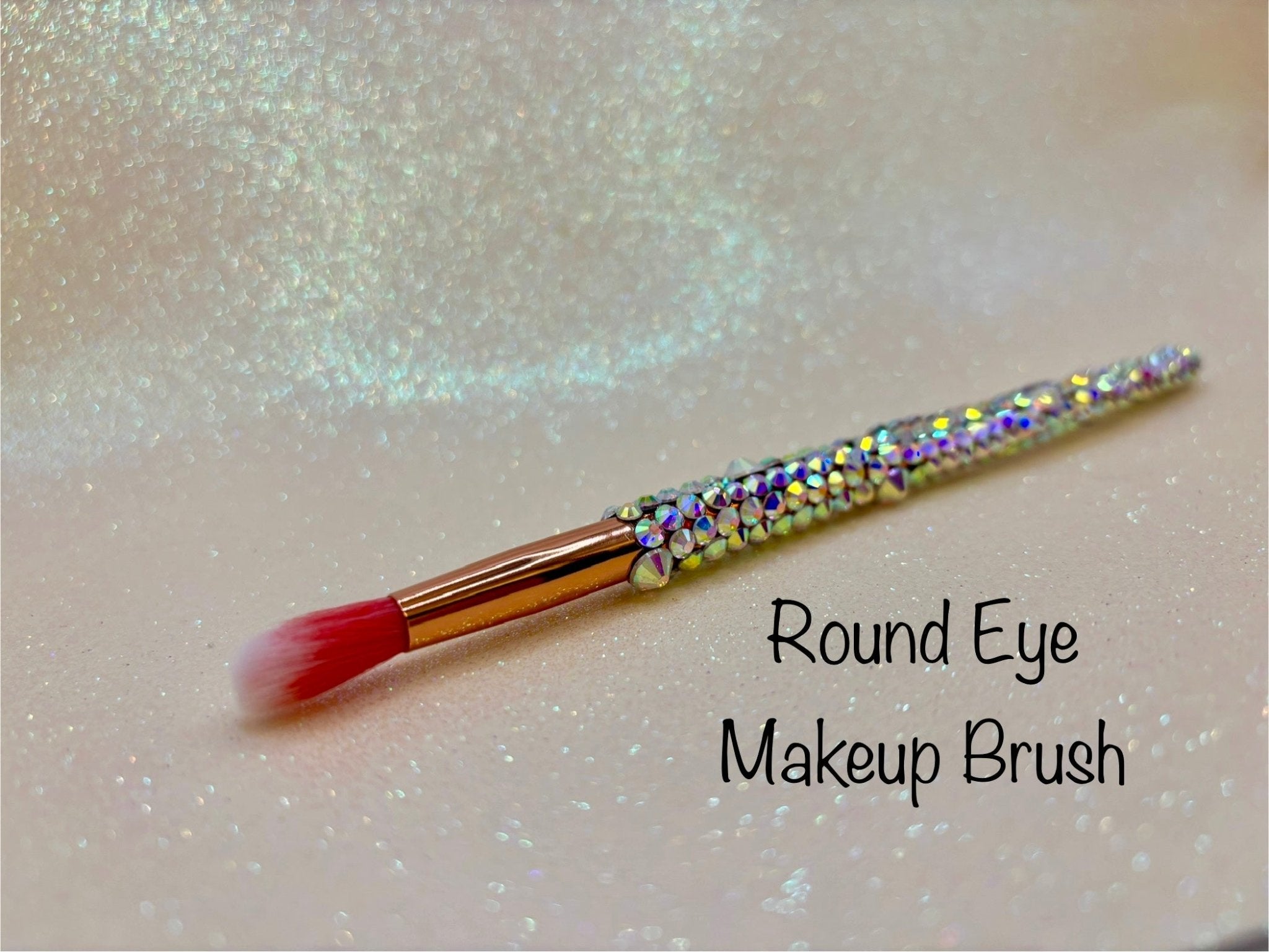 Round Eye Makeup Brush with a full aurora crystal handle, gold ferrule and pink bristles by La Paz Cosmetics on a white background 