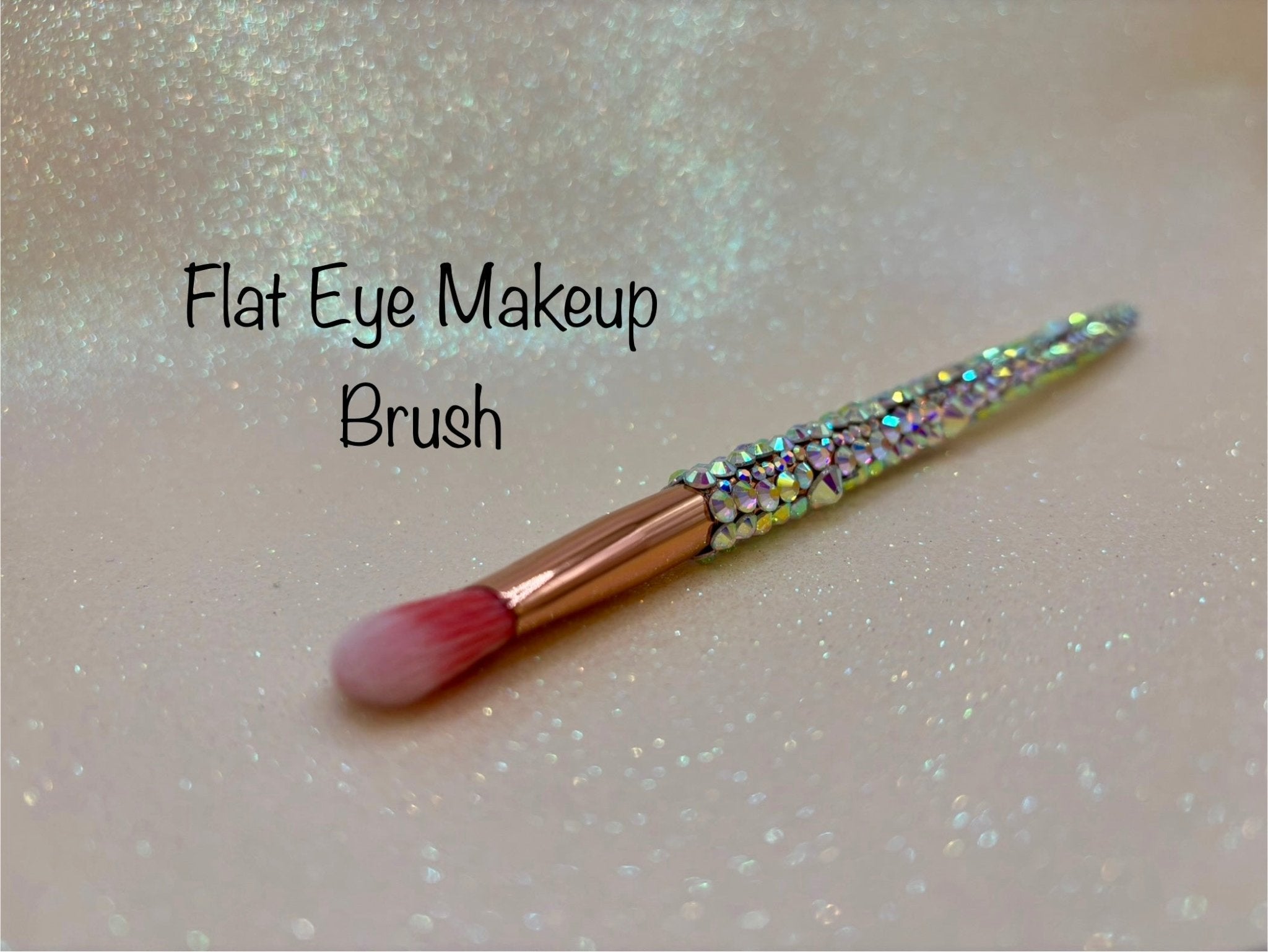 Flat Eye Makeup Brush with a full aurora crystal handle, gold ferrule and pink bristles by La Paz Cosmetics on a white background 