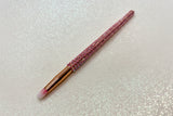 round detail eye makeup brush with pink bristles and a pink rhinestone handle on a sparkly background by La Paz Cosmetics