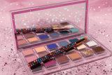Mercury Eyeshadow Palette open with 18 colorful matte, shimmer, and glitter shades on a pink glitter background