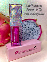 A pink Jupiter lip oil in a clear tube with a crystal embellished cap, displayed on a box with 'La-Paz.com' branding.