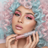 Model with pastel curly hair holding La Paz Crystal Frosting Lip Gloss in Cotton Candy D02 with sheer pink shimmer lips