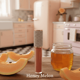 La Paz M13 Honey Melon Diamond Liquid Matte Lipstick with rhinestone cap beside honey jar and melon slices on rustic wood