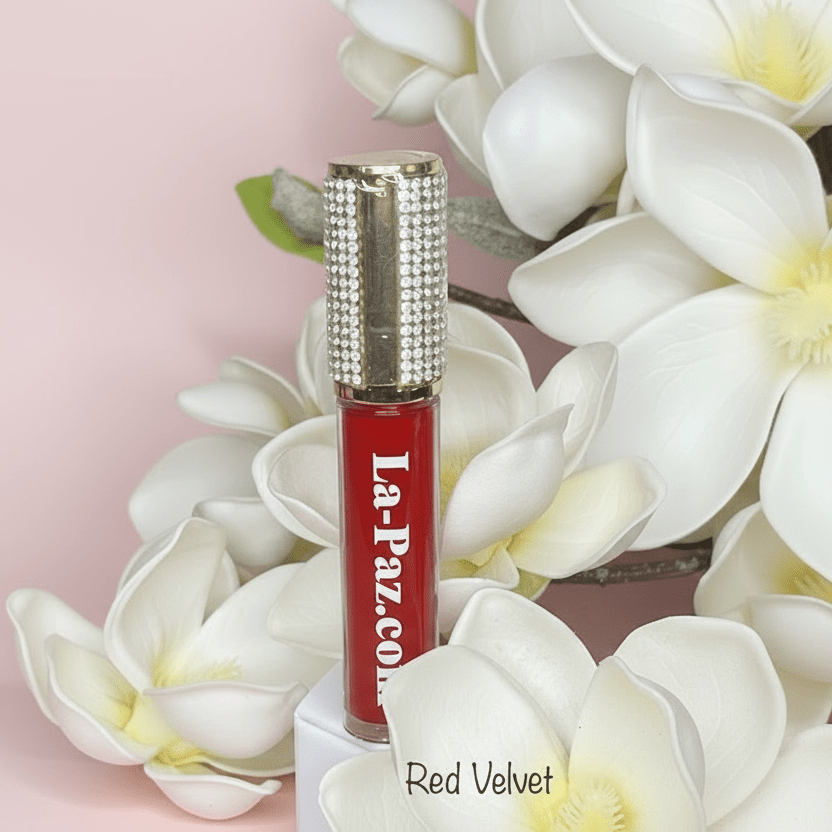 La Paz M40 Red Velvet Diamond Liquid Matte Lipstick with rhinestone cap among white magnolia flowers on pink background