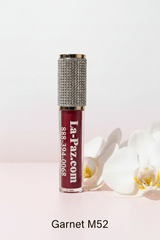 La Paz M52 Garnet Diamond Liquid Matte Lipstick — rhinestone cap, deep brownish-red shimmer formula on blush background