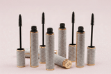 Five La Paz Cosmetics Luxe Lengthening Mascara tubes with rhinestone-encrusted gold cases open with wands displayed