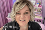 Founder at a cosmetics event with pink decor and wearing Pink Me lip oil.