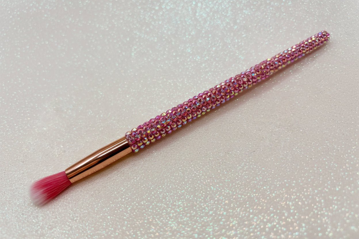 Round blending for eye makeup brush with pink bristles and a pink rhinestone handle on a sparkly background by La Paz Cosmetics